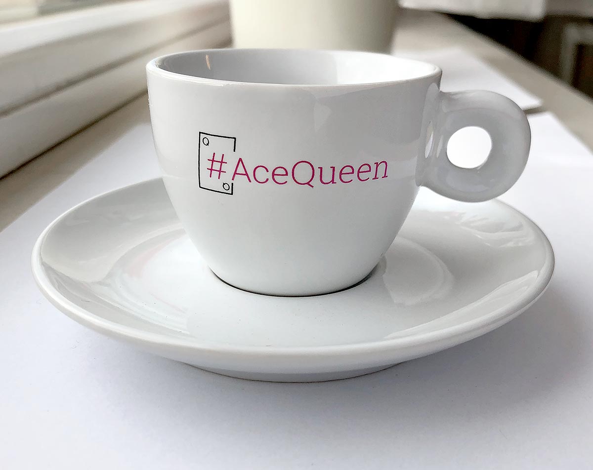 Reklamní bílý porcelánový šálek s podšálkem a potiskem loga #AceQueen