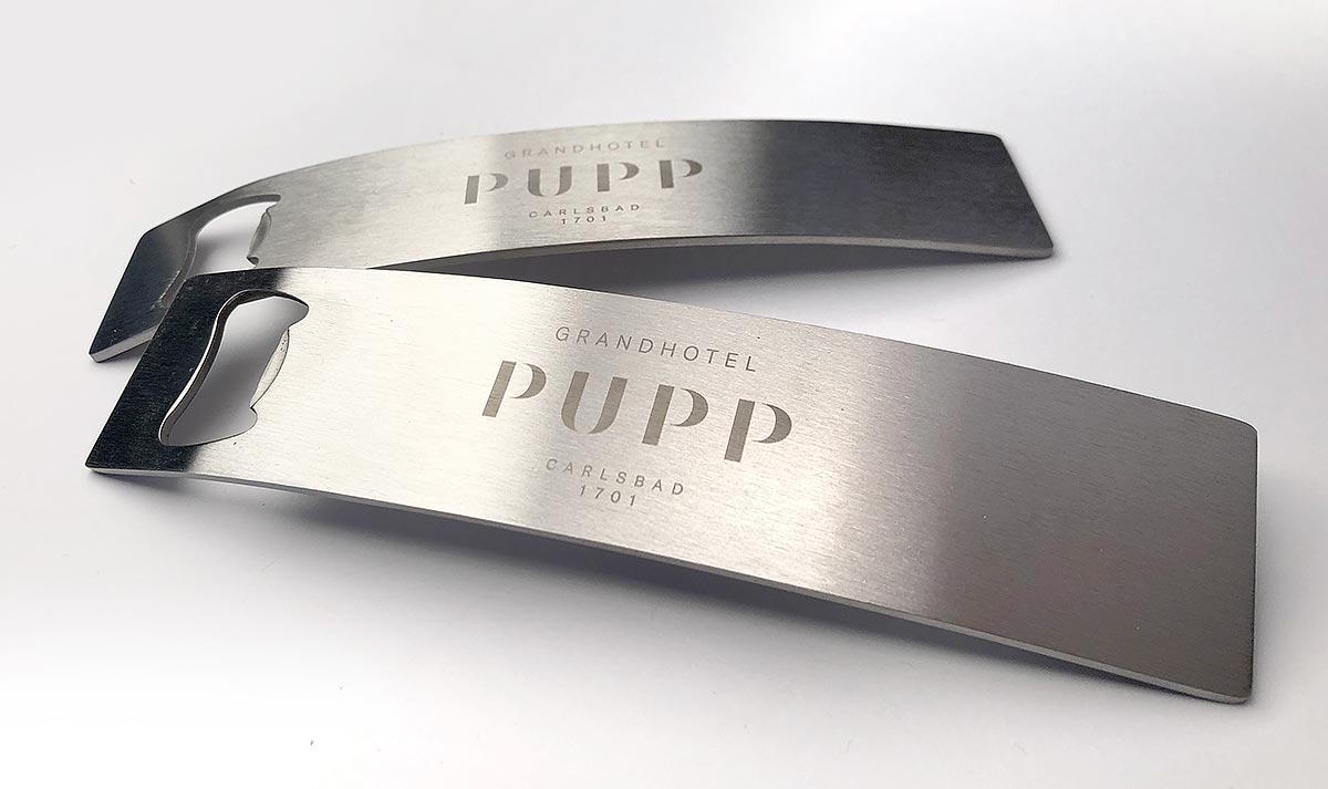 Reklamní kovový otvírák na lahve s gravírovaným potiskem Grandhotel Pupp